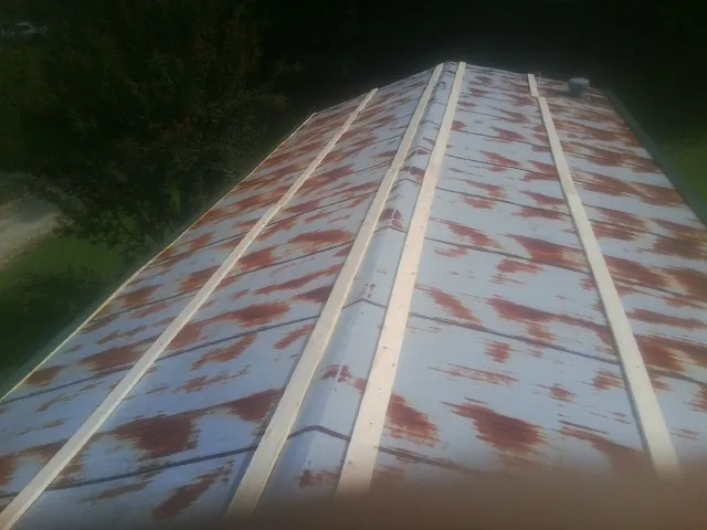 Rusted metal roof panels with new wood purlins before replacement — Storm Damage Roof Repair in Dunedin by Roofing Brothers
