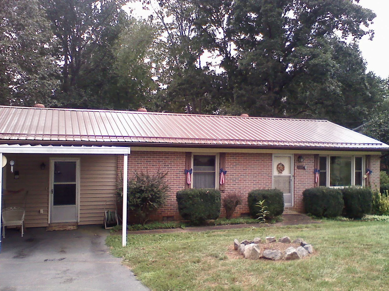 Bronze metal roof and carport on a brick ranch home — Roof Repair work by our crew in Dunedin